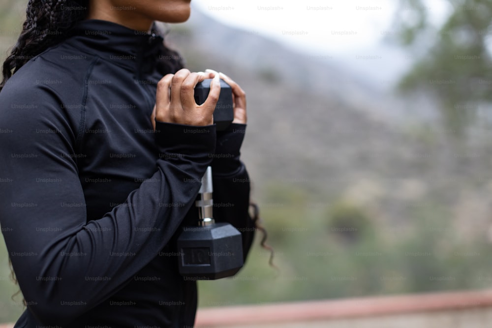 a woman in a black top holding a black object