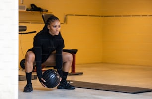 a woman squatting on a mat in a gym