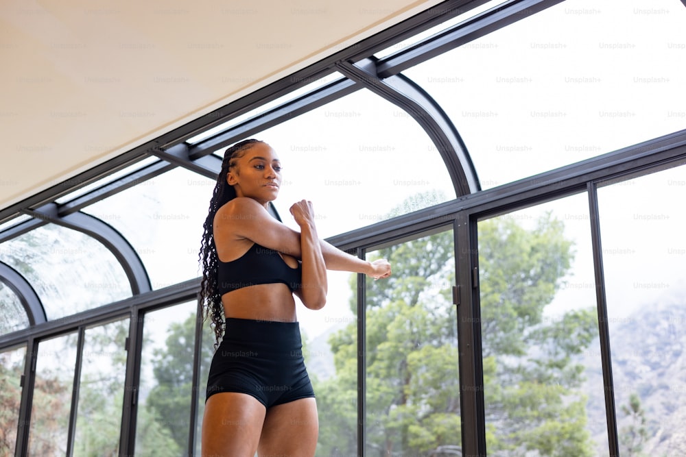 a woman in a black sports bra top and black shorts