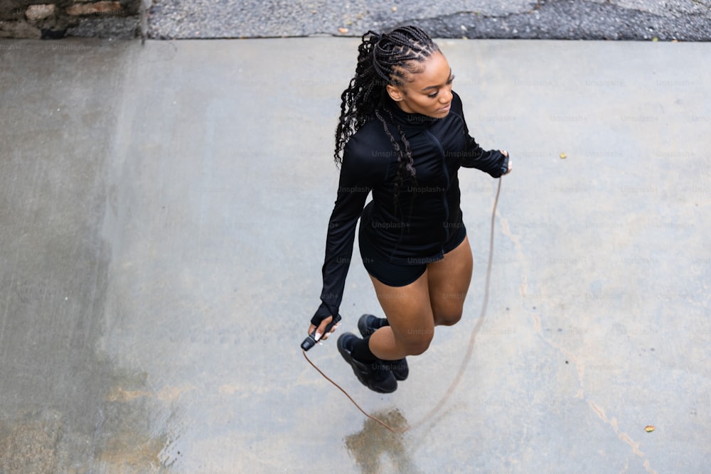 a woman in a black shirt is on a skateboard