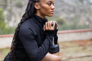 a woman holding a black object in her right hand