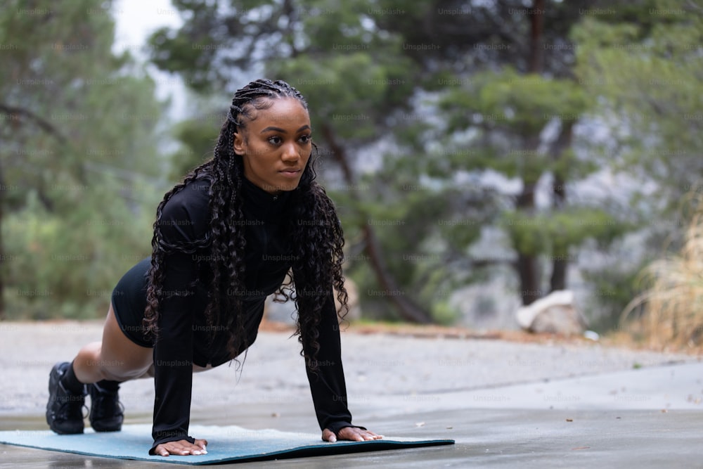 Una mujer está haciendo flexiones en una esterilla de yoga