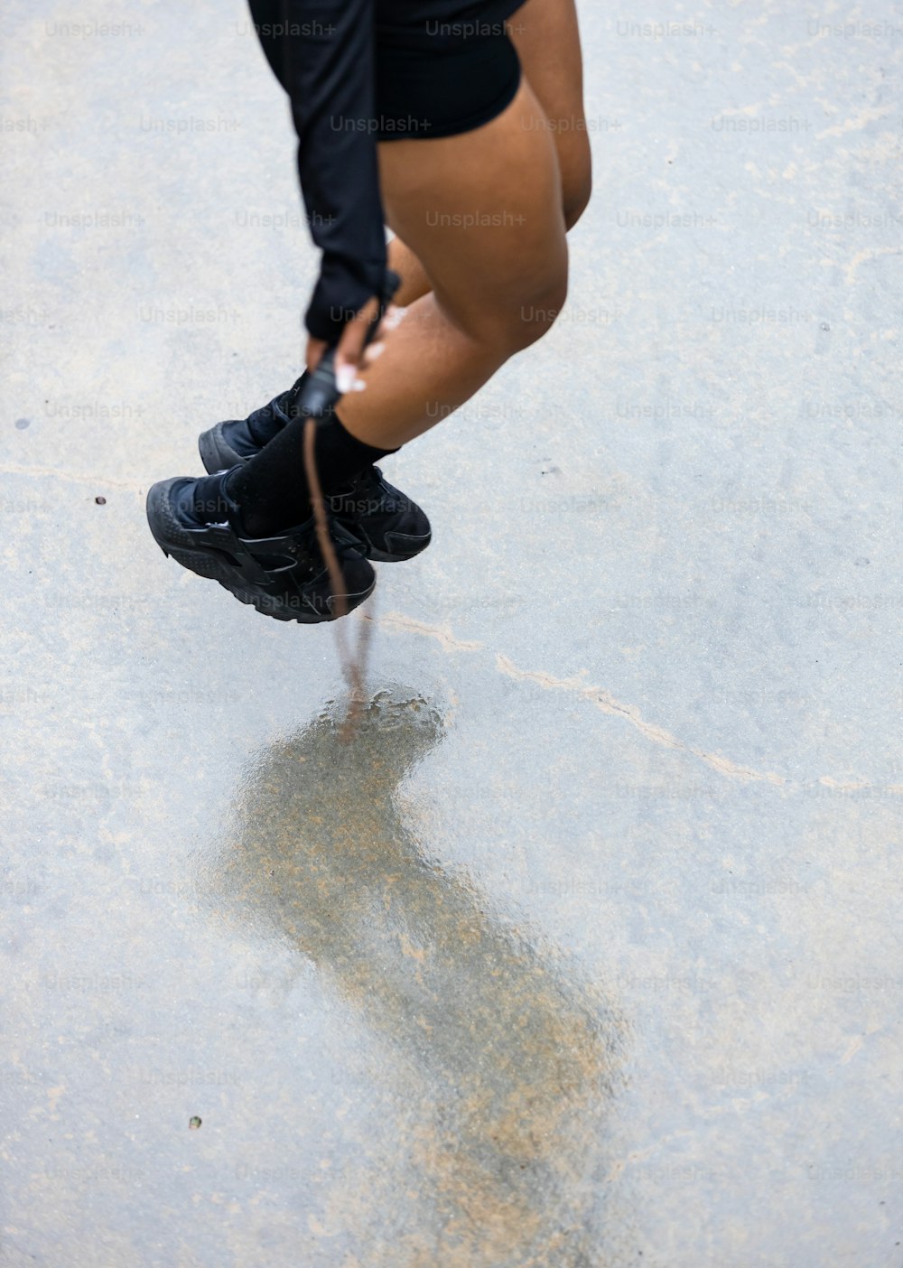 une personne debout sur une planche à roulettes sur une surface en béton