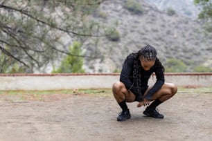 a woman squatting down in the dirt