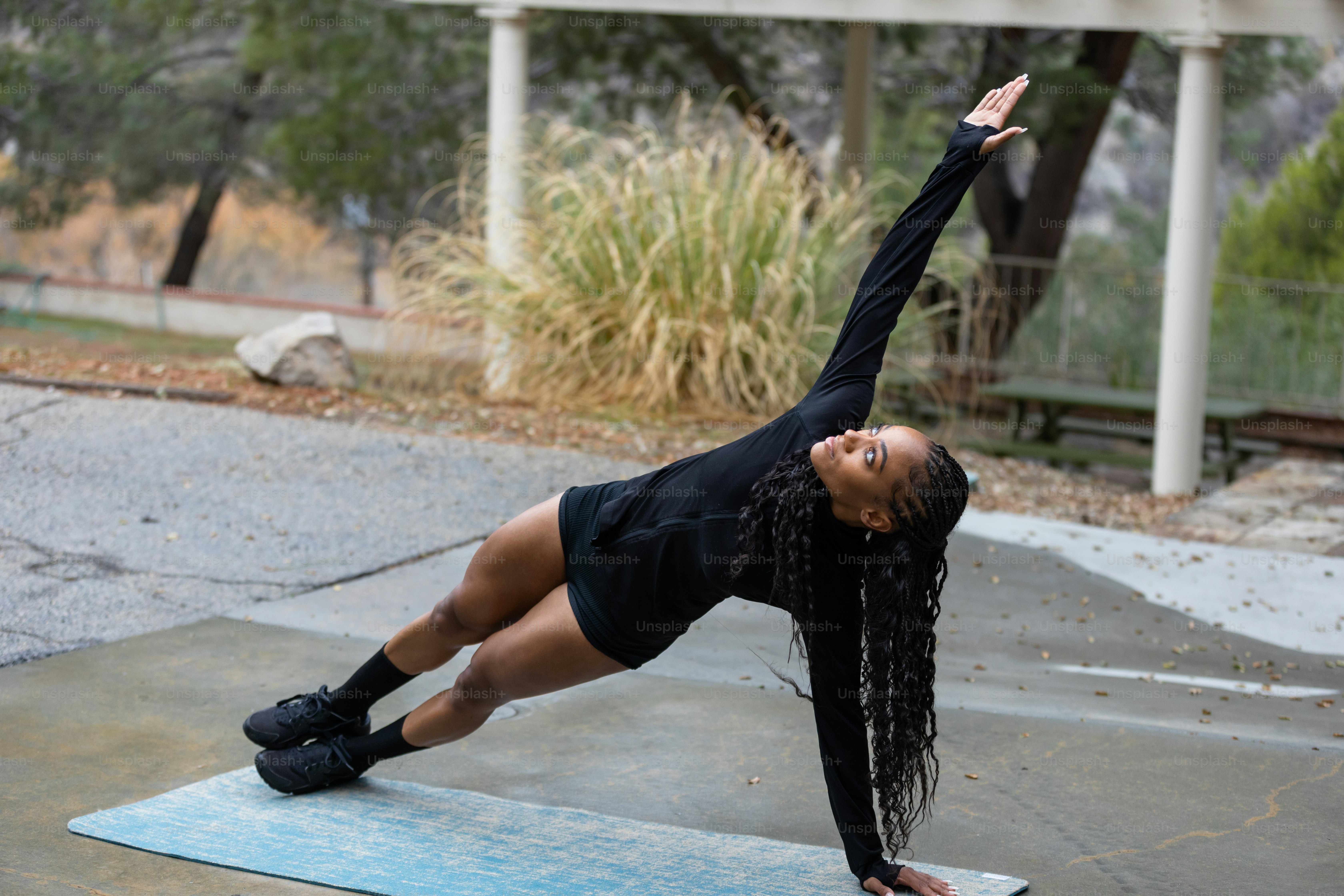 a woman doing a yoga pose on a blue mat