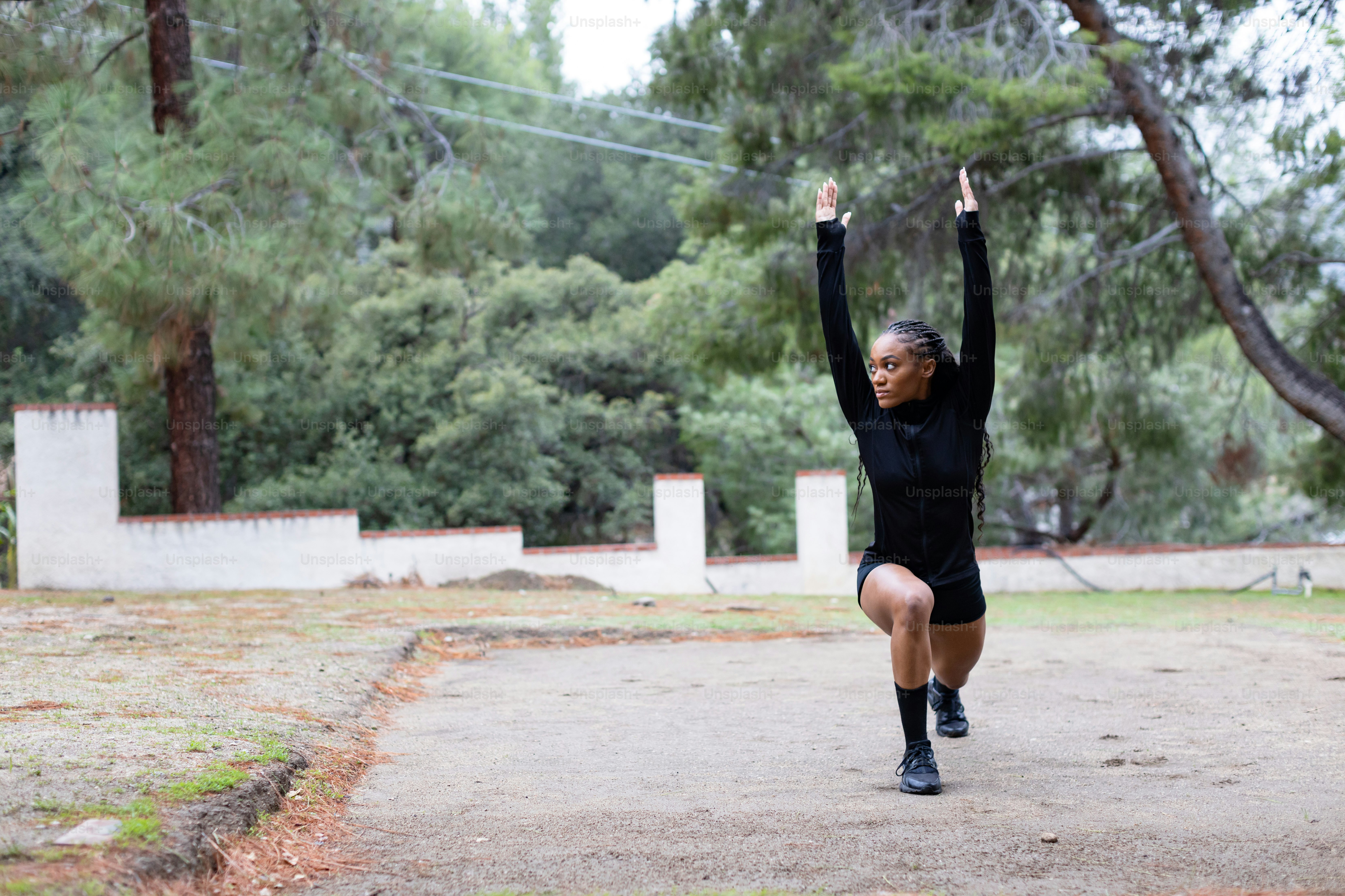 a woman in a black shirt is doing a yoga pose
