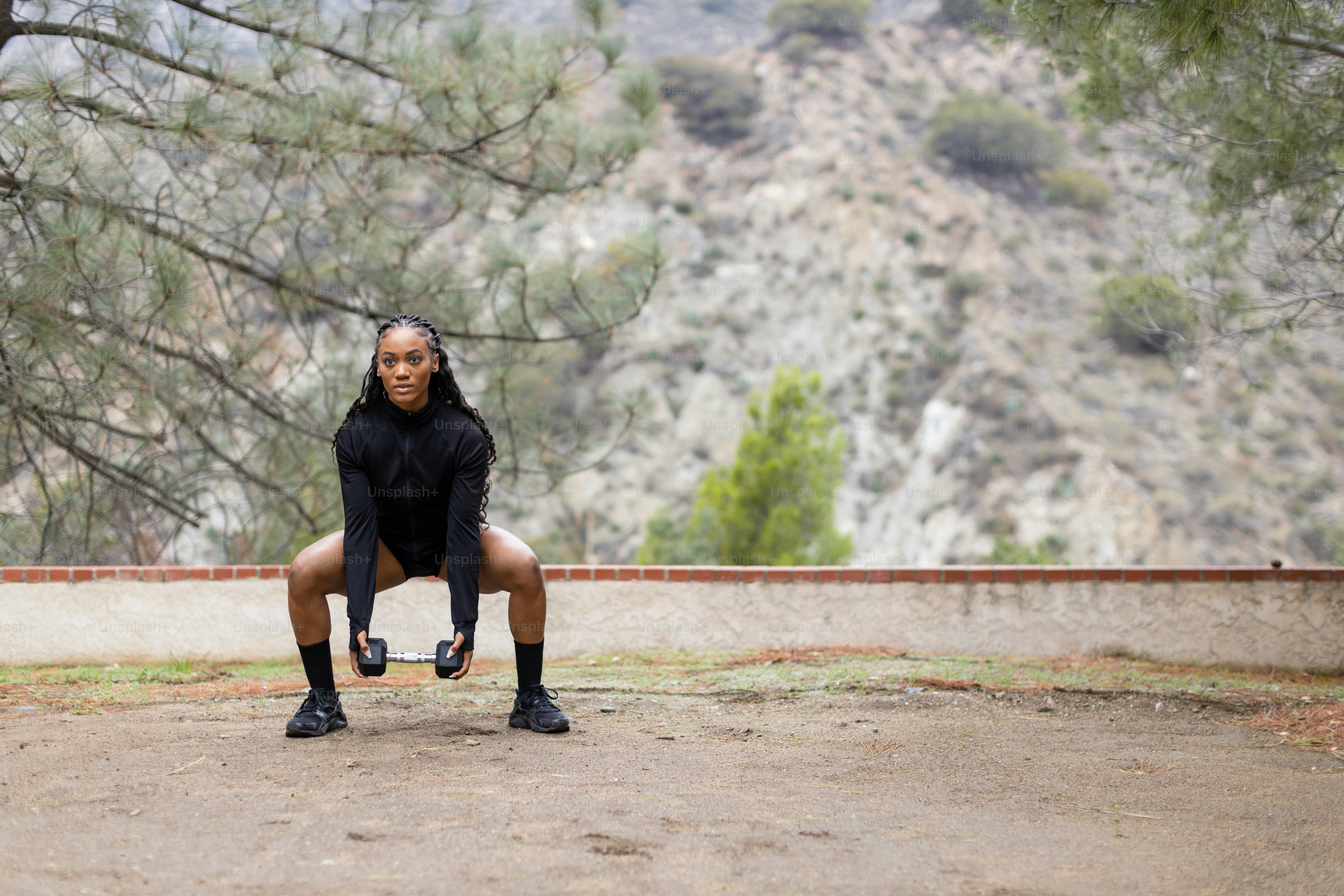 a woman is squatting down in a park