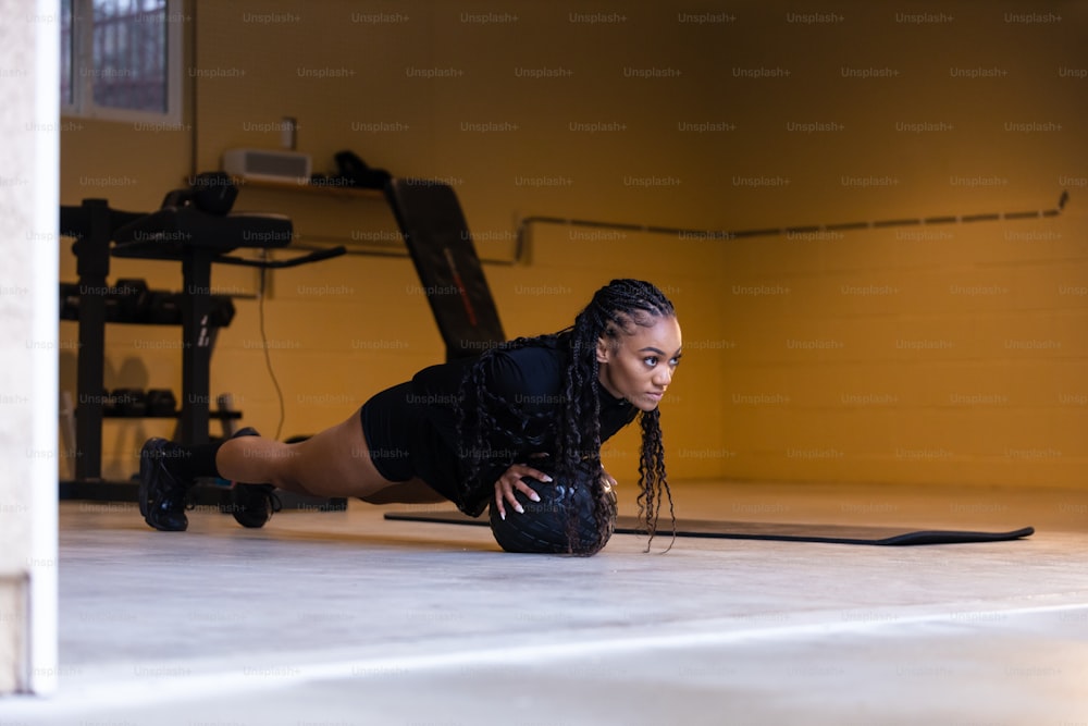 a woman is doing push ups in a gym