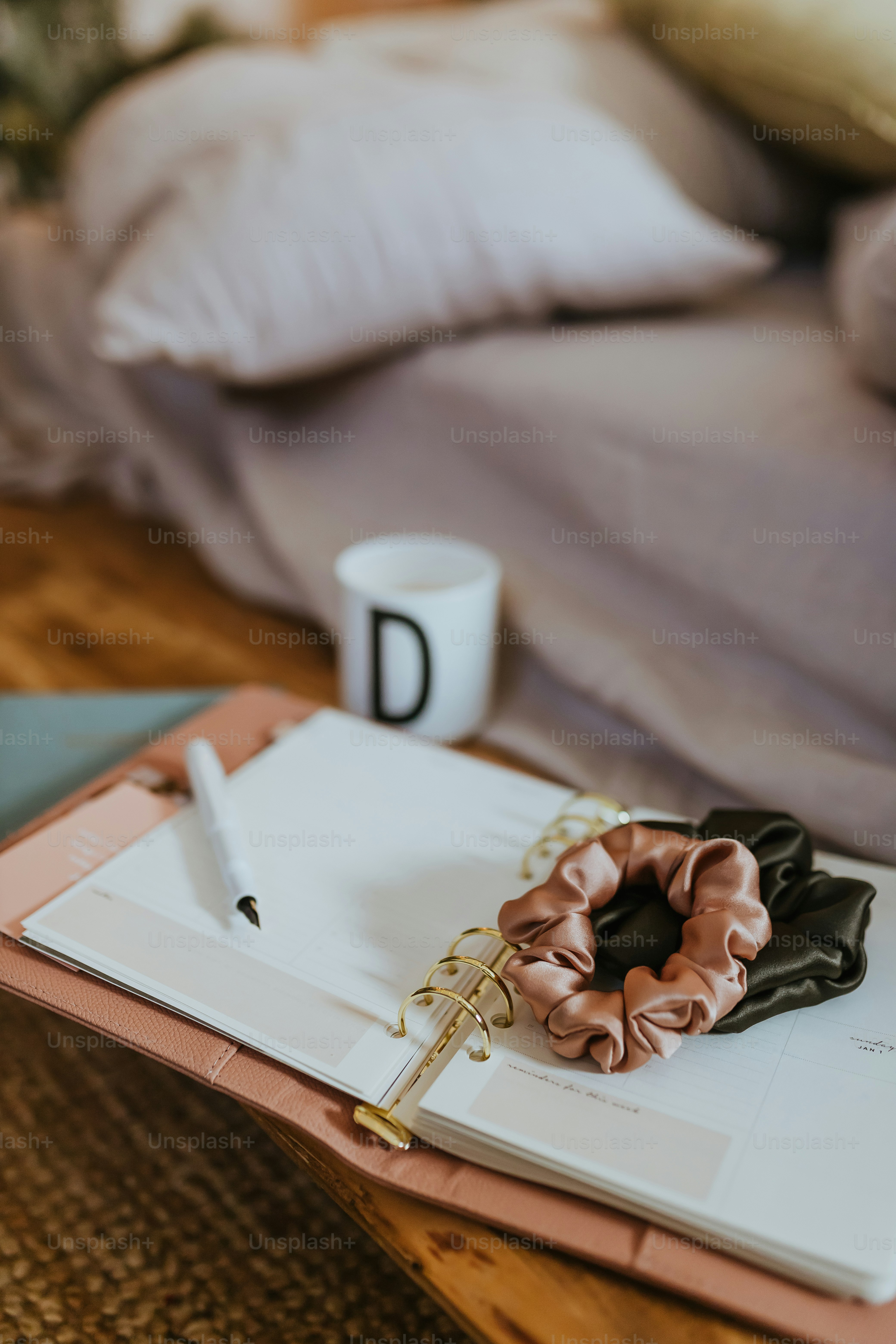 a notebook with a pink scrunffle on top of it