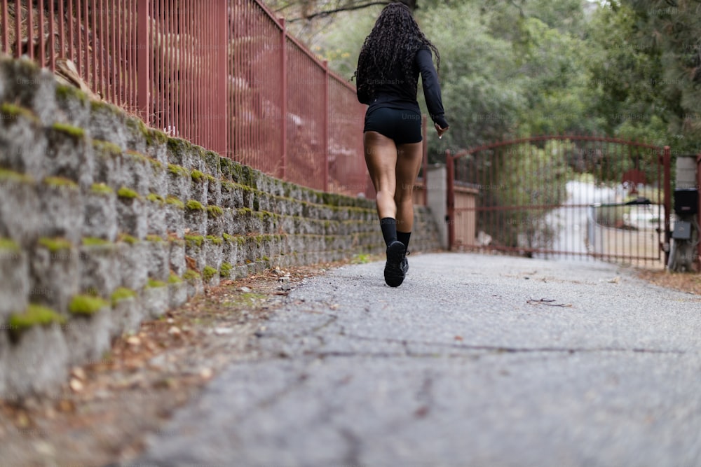 a woman running down a path in the rain