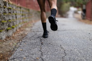 a person running down a street with black shoes