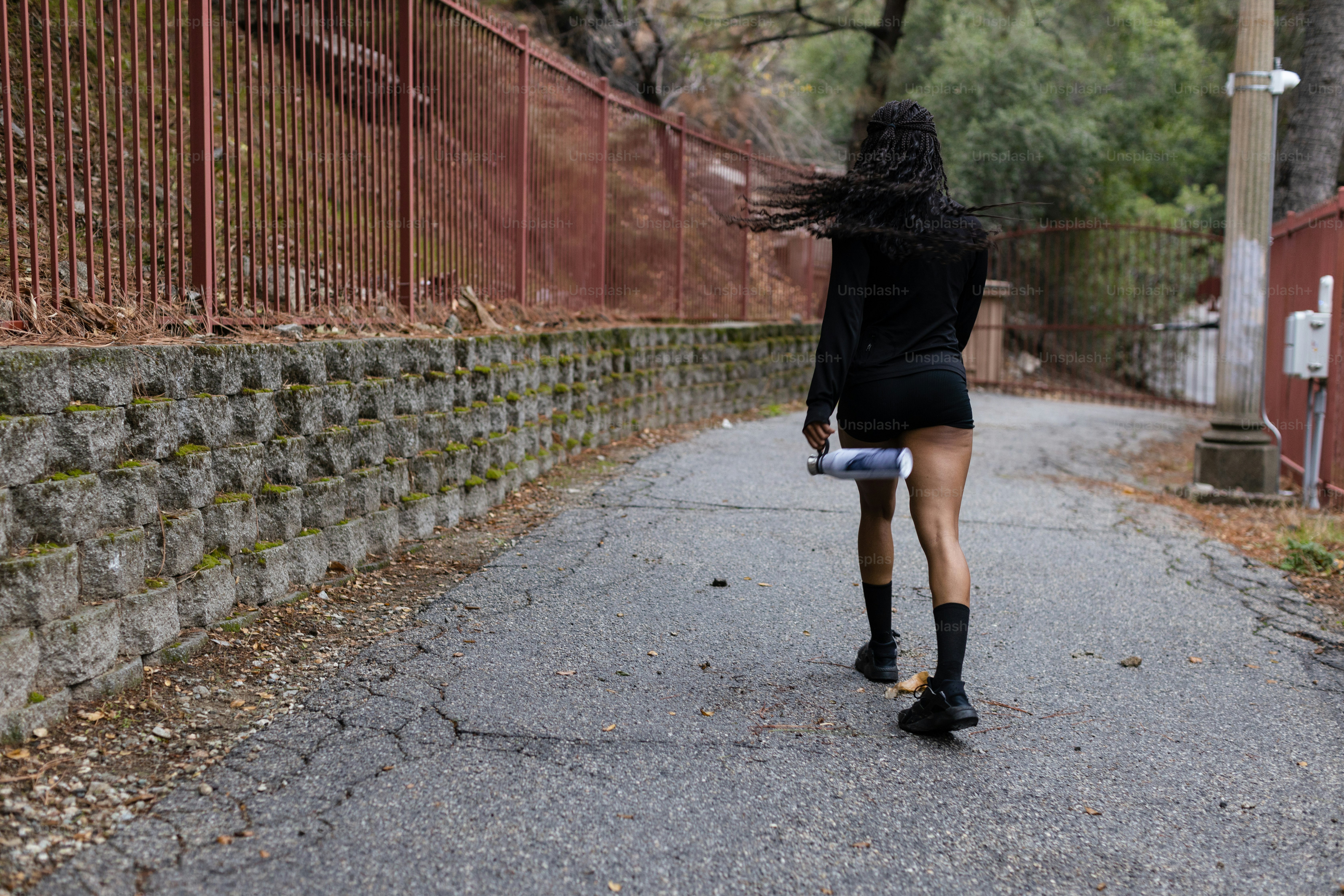 Una donna che cammina lungo una strada con un ombrello