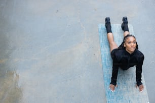 Una mujer acostada encima de una estera azul