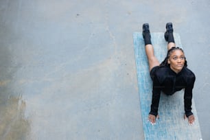 a woman laying on top of a blue mat