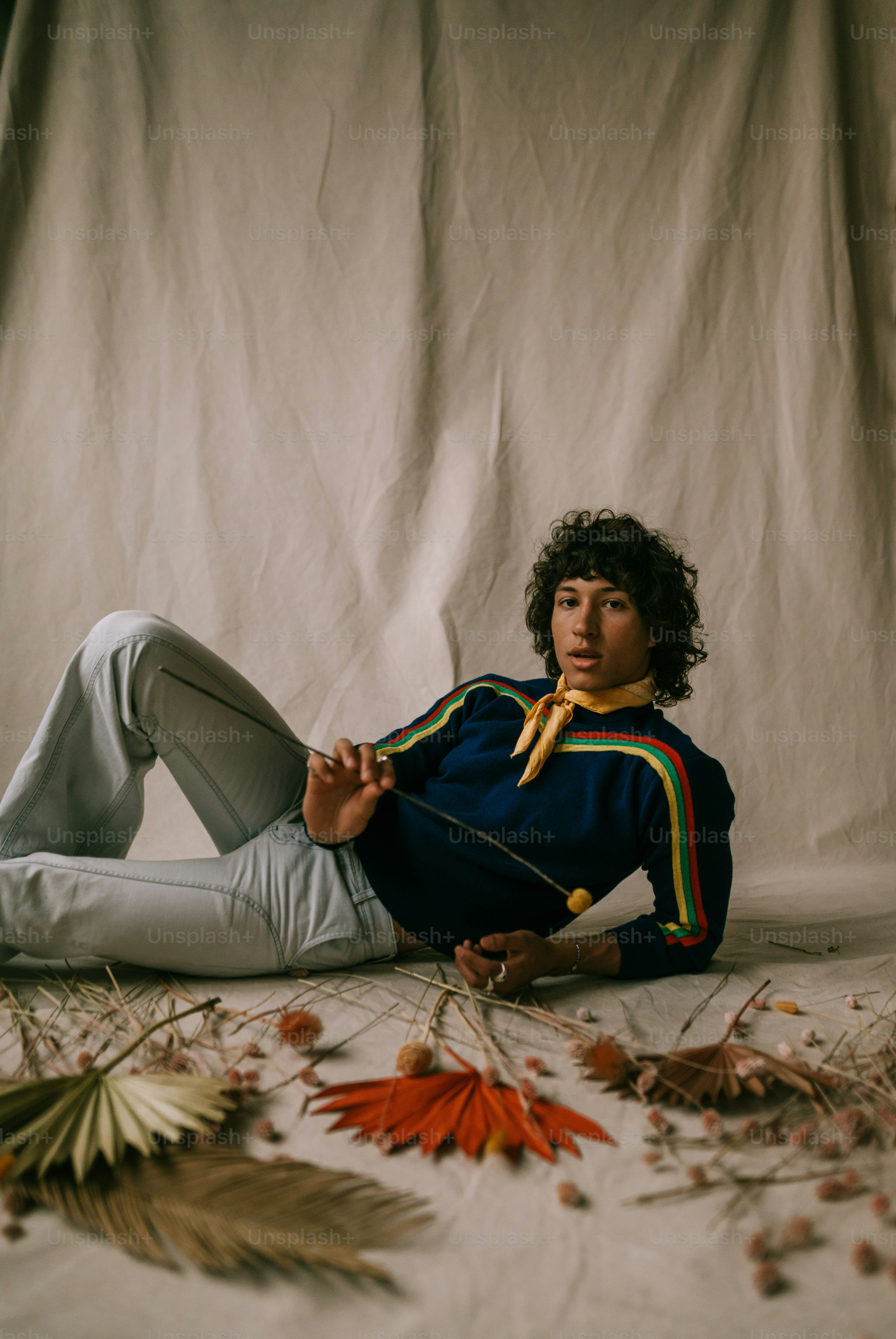 Ein junger Mann sitzt mit einer Krawatte um den Hals auf dem Boden