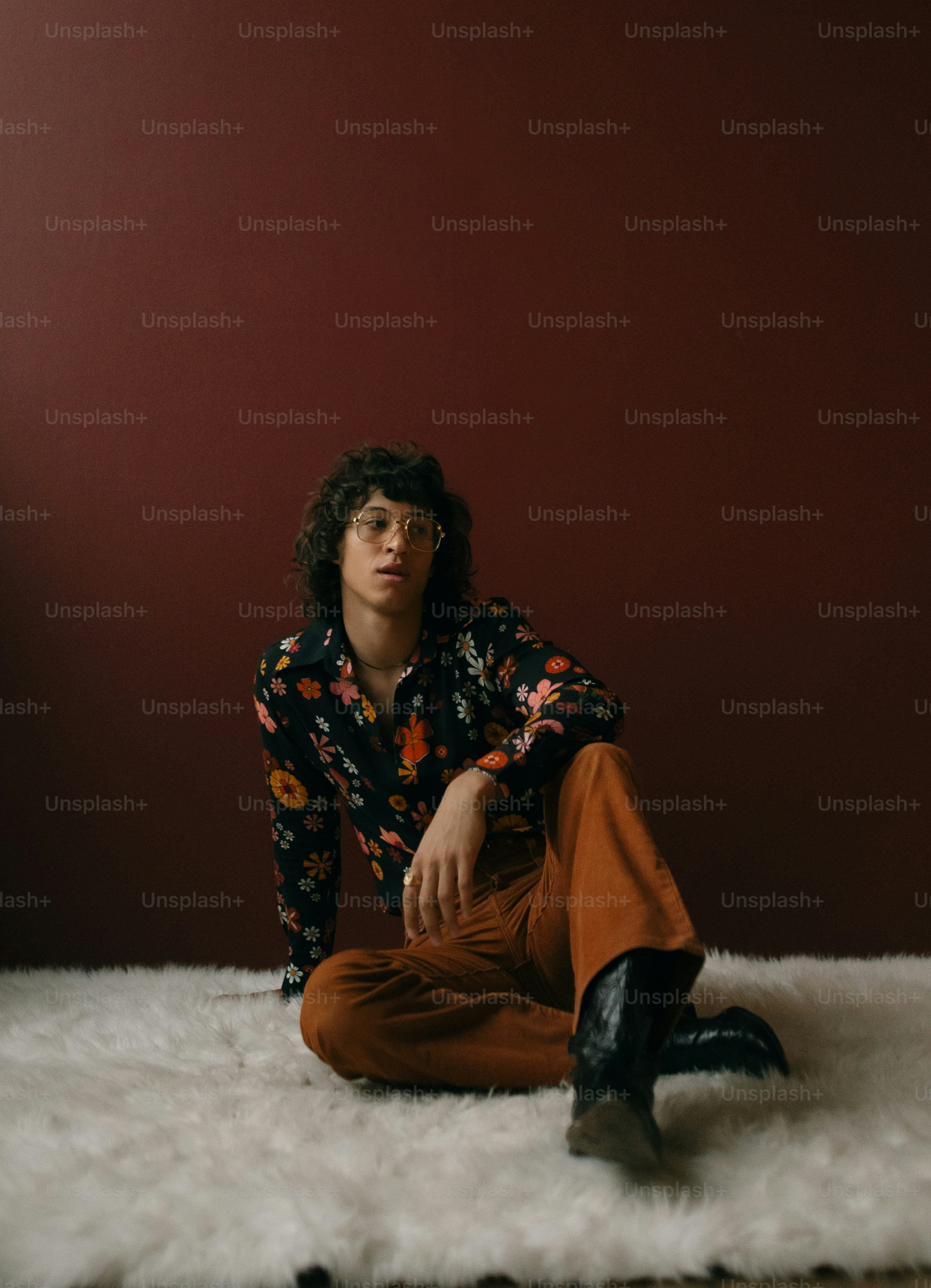 Eine Frau sitzt auf einem weißen Teppich vor einer roten Wand