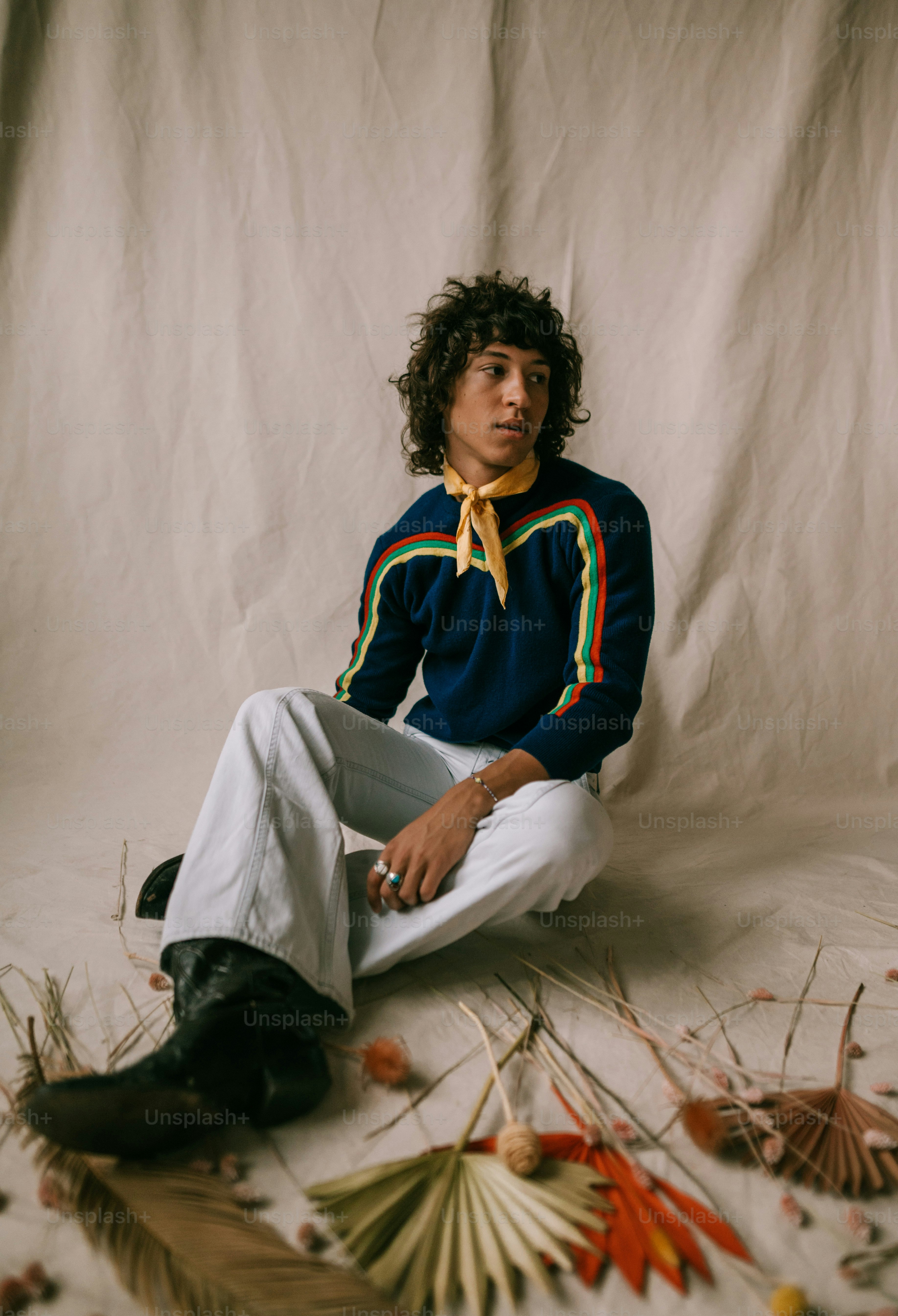 a man sitting on the ground with a bunch of flowers around him