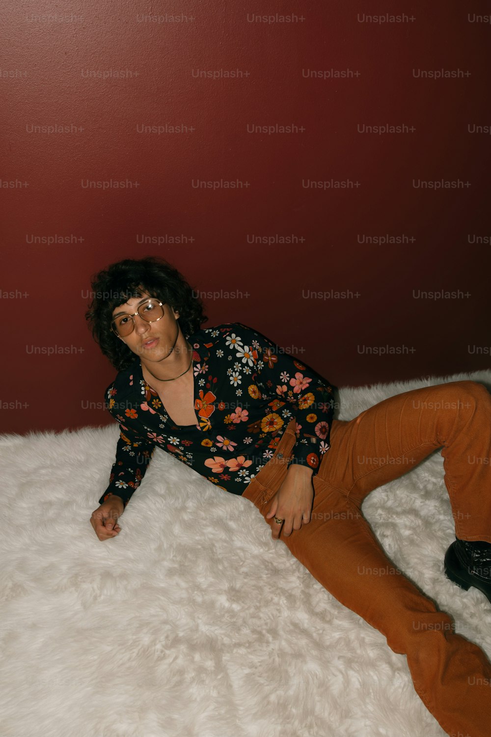 Una mujer está acostada sobre una alfombra blanca y esponjosa