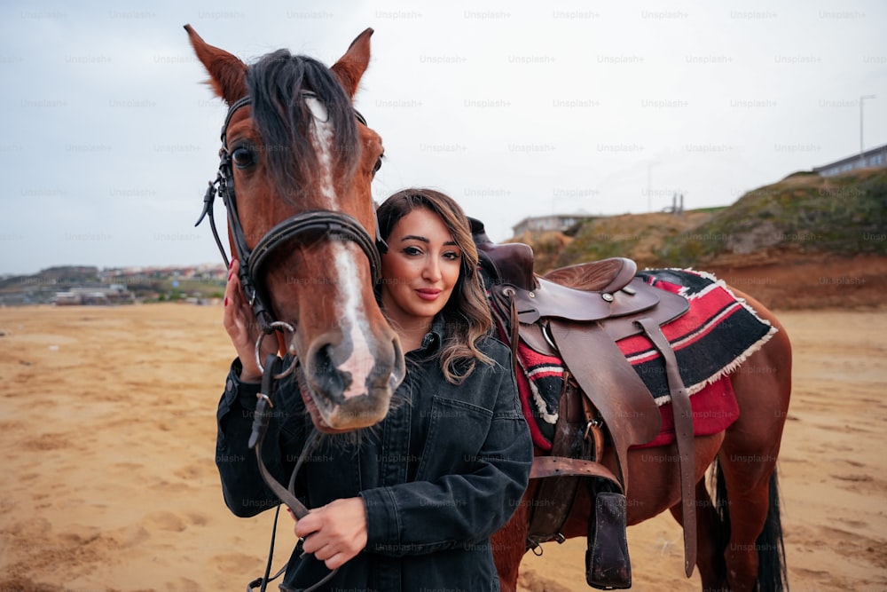 uma mulher bonita de pé ao lado de um cavalo marrom
