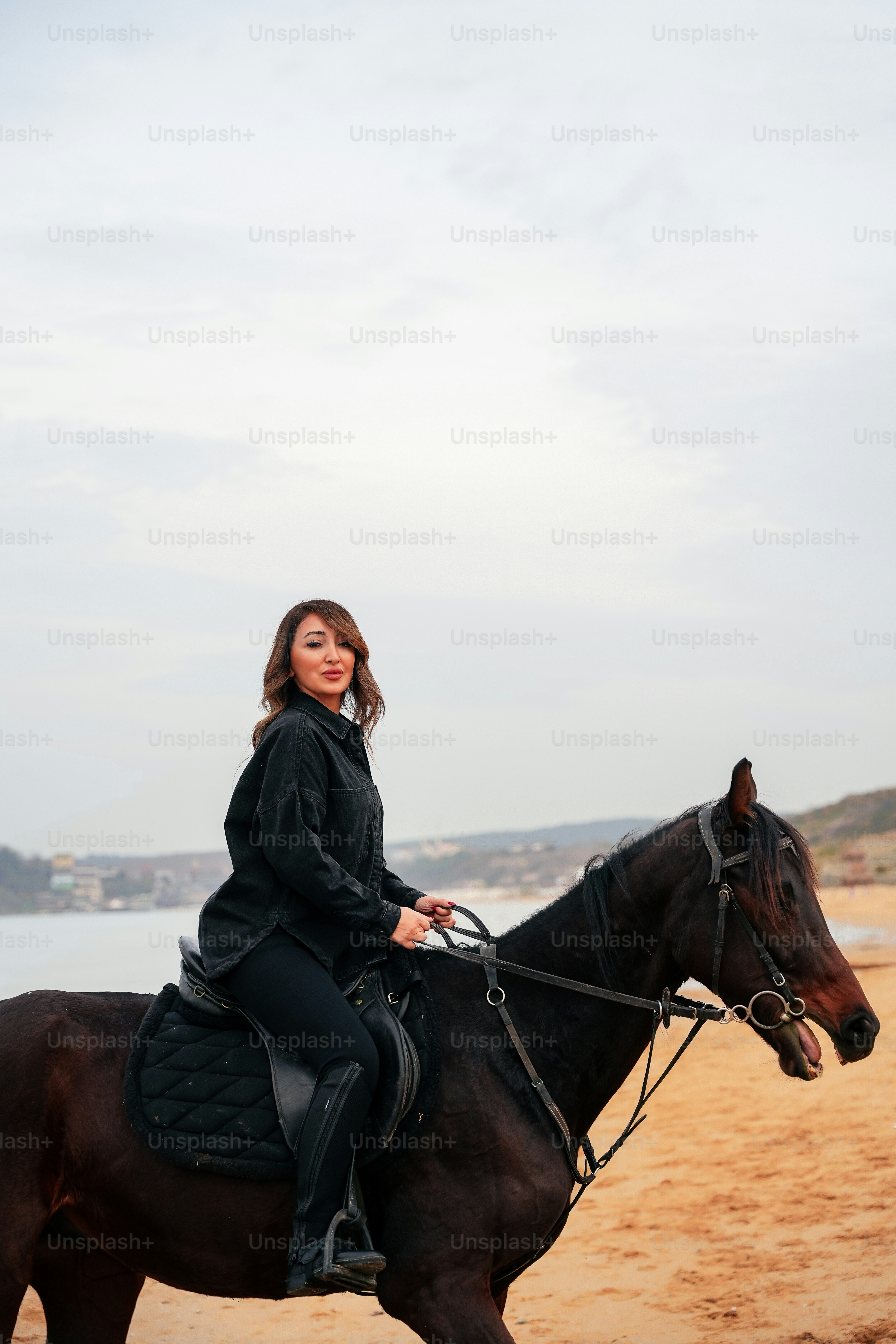 a woman is riding a horse on the beach