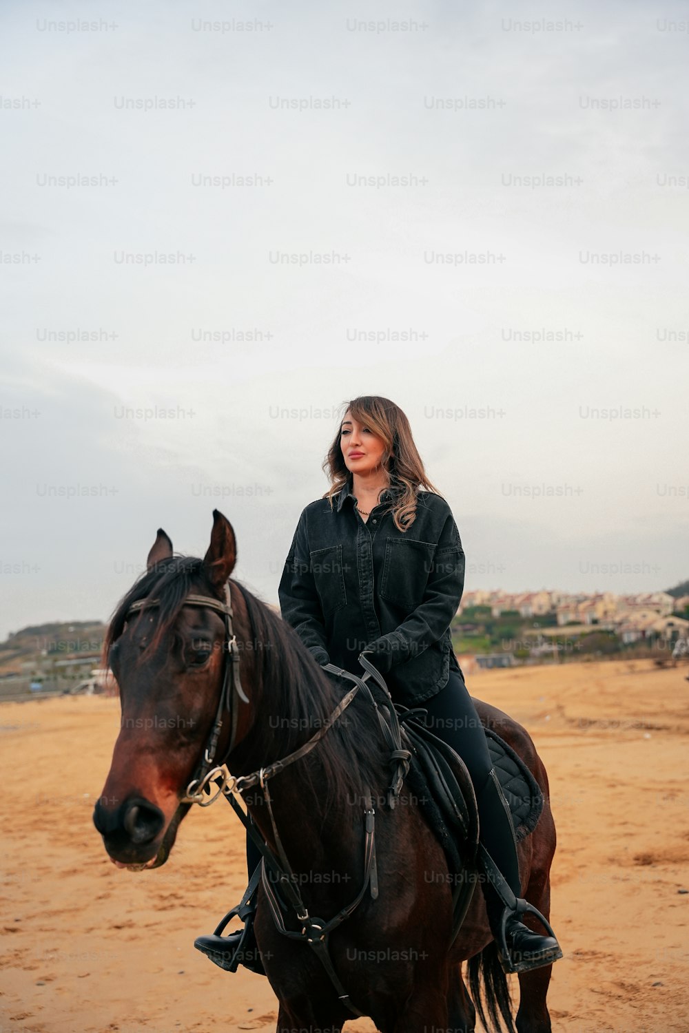 Una donna che cavalca sul dorso di un cavallo marrone