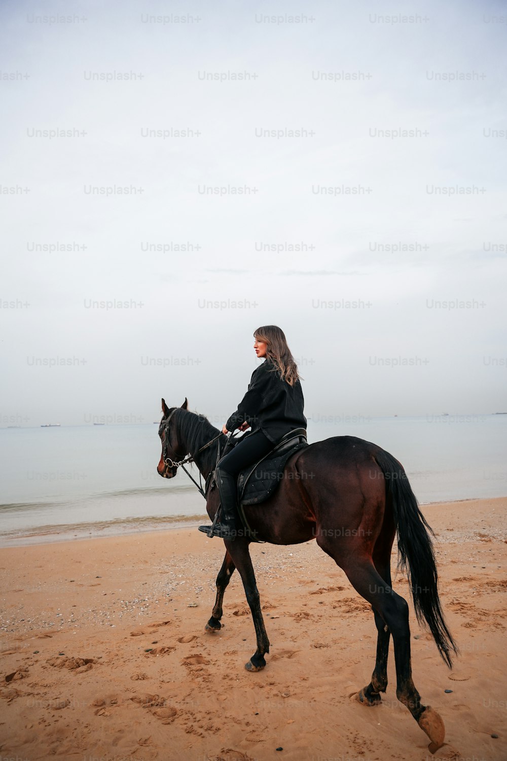 Eine Frau reitet auf dem Rücken eines braunen Pferdes