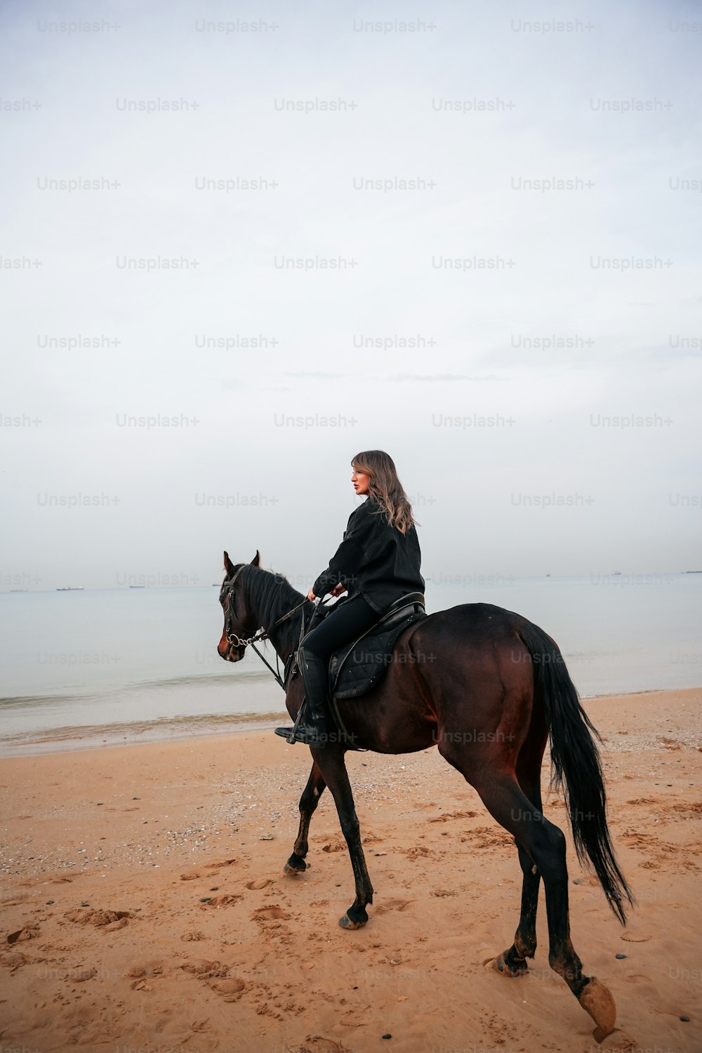 a woman riding on the back of a brown horse