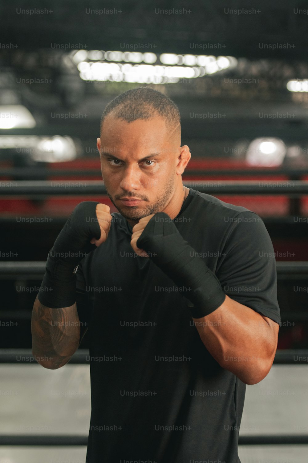 Un hombre con camisa negra y guantes de boxeo