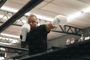 Ein Mann in schwarzem Hemd und weißen Boxhandschuhen