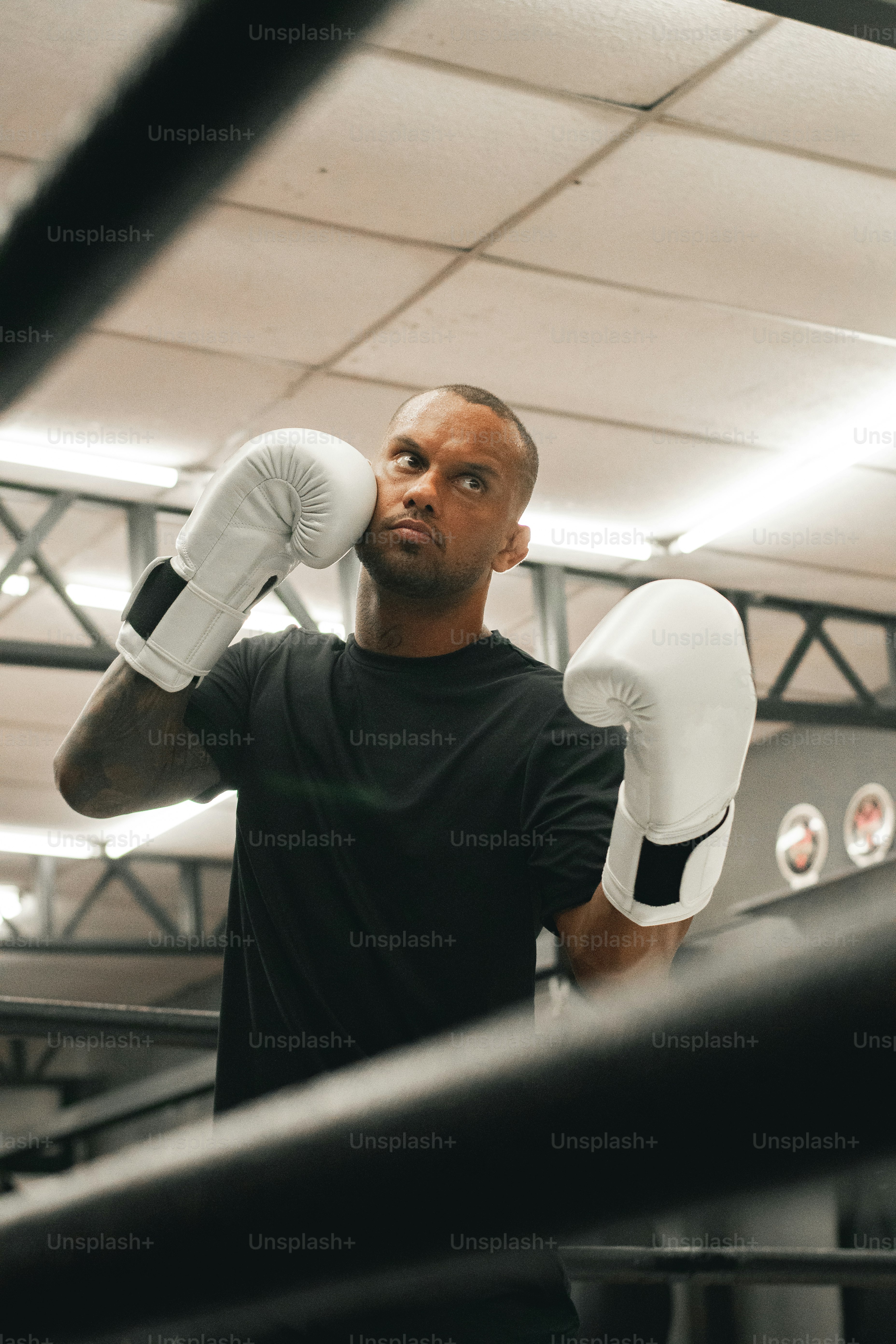 a man in a black shirt and white boxing gloves