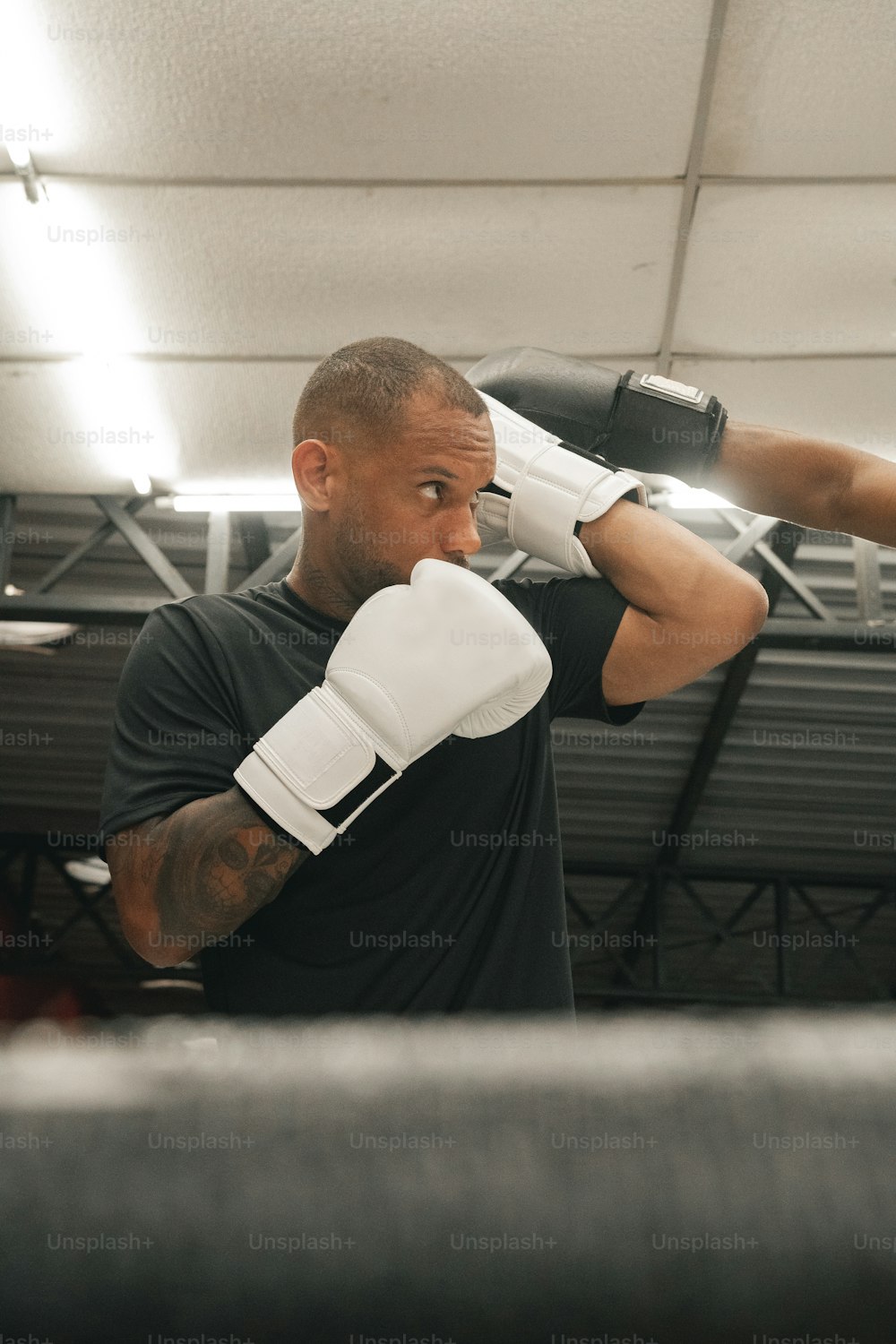 a man in a black shirt and white boxing gloves