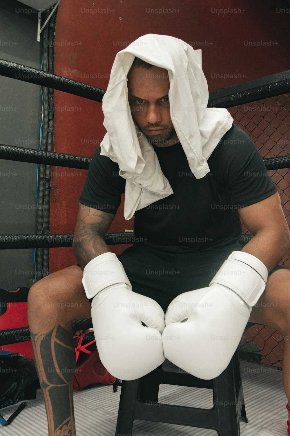 a man sitting on a stool wearing boxing gloves