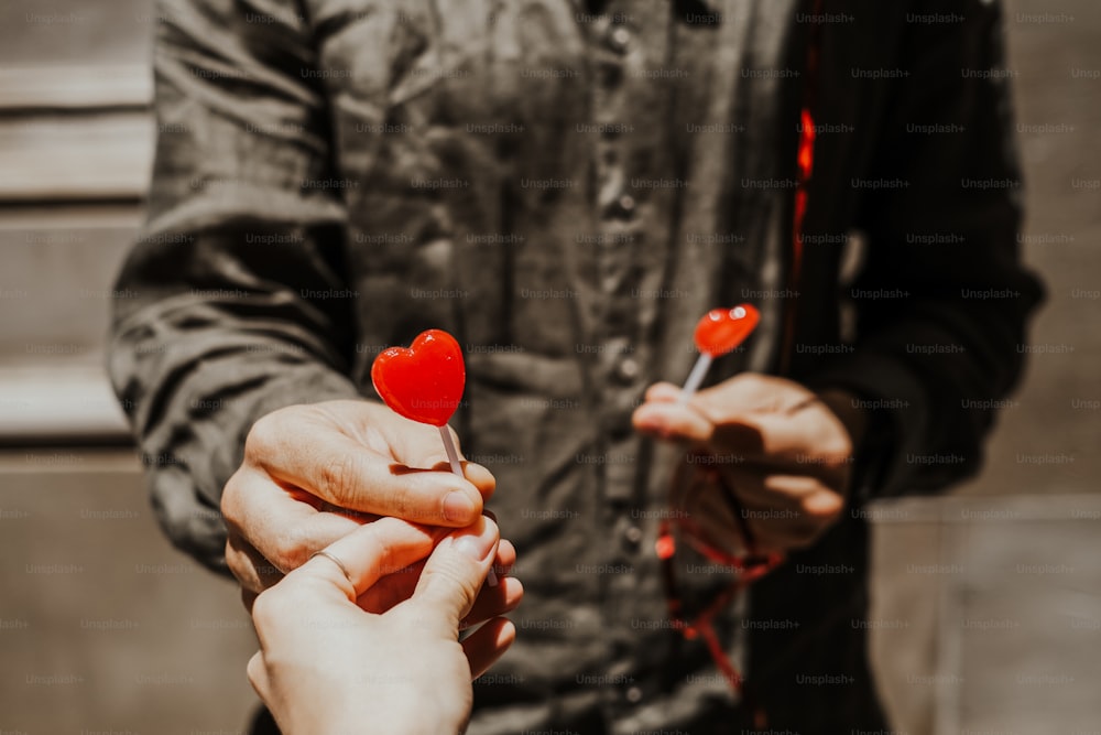Un homme et une femme tenant une sucette en forme de cœur