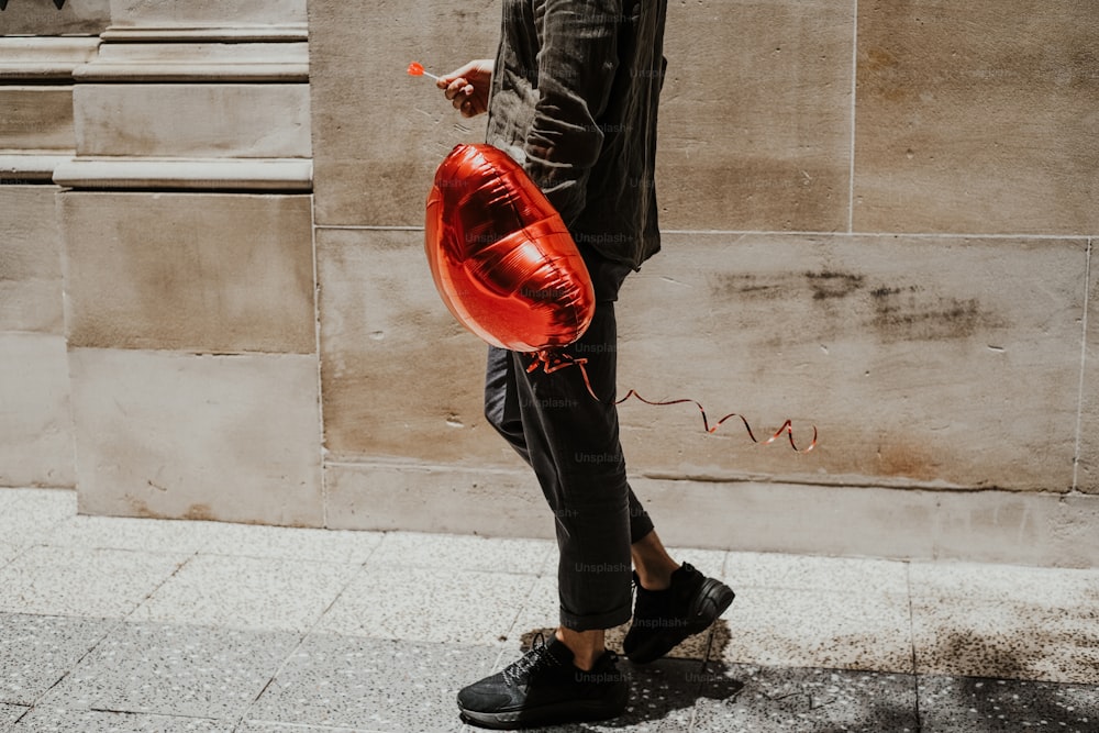 Un hombre con un globo rojo en la mano