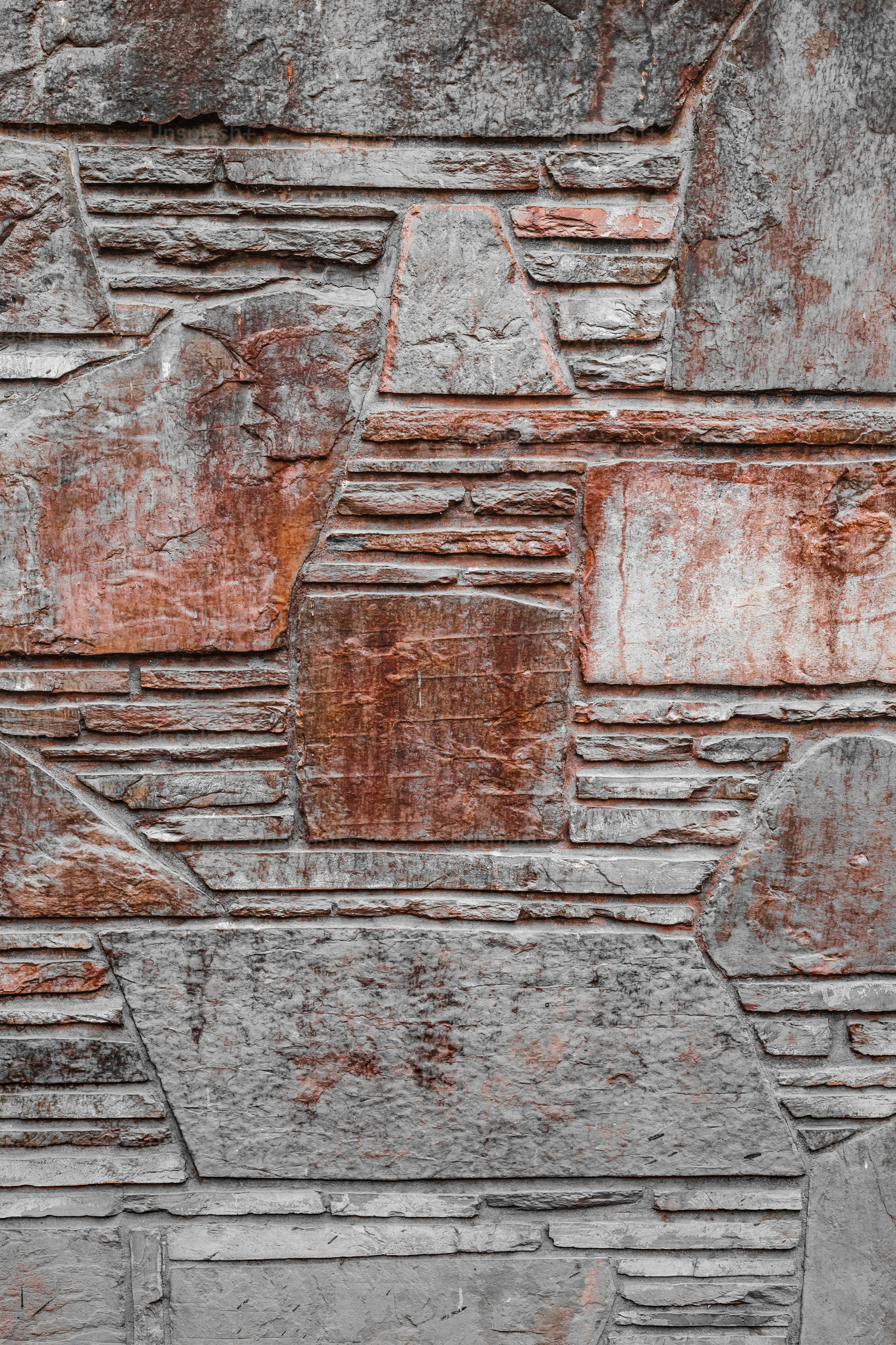 eine Steinmauer mit einer Bank davor