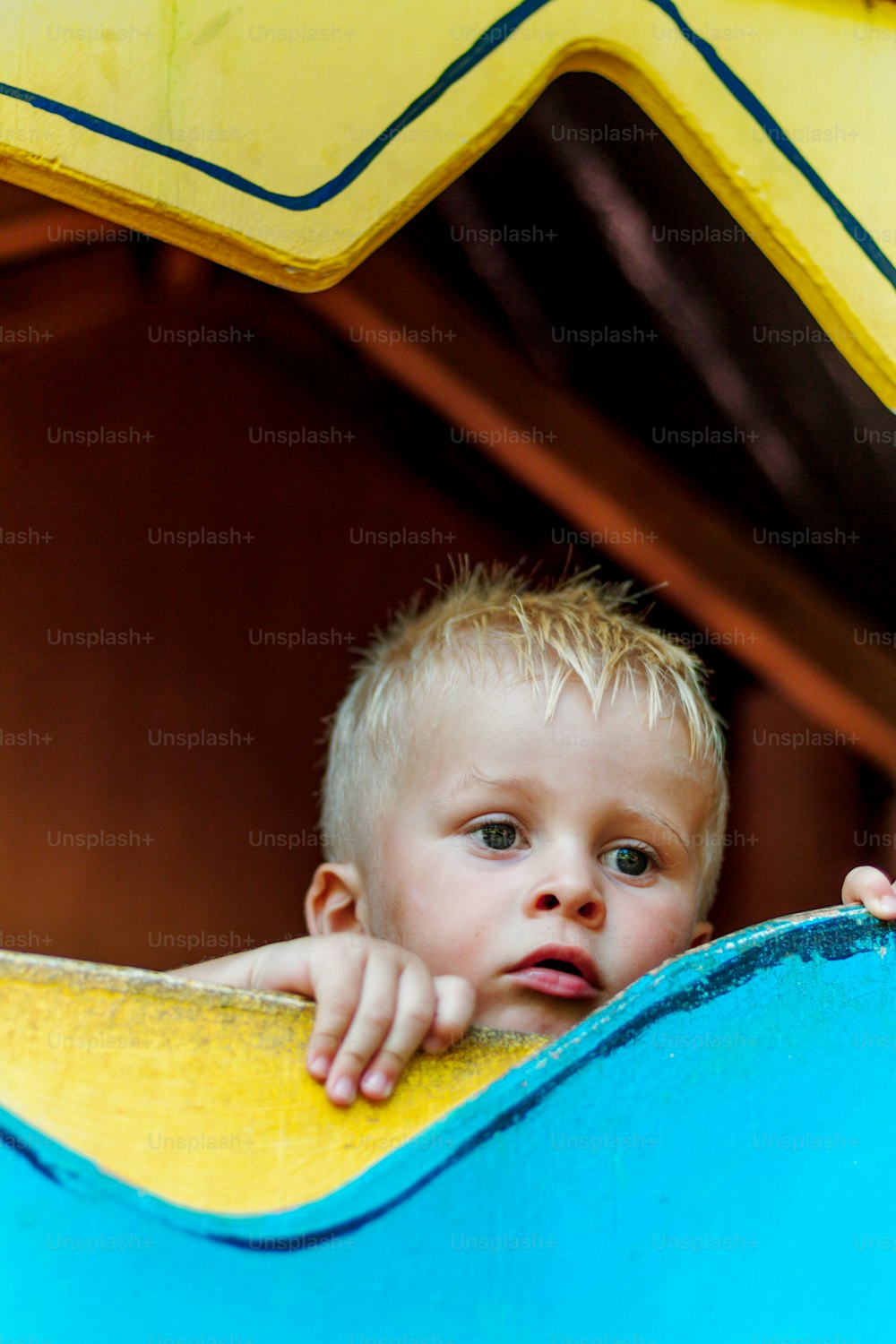 Un niño pequeño que está sentado en un tobogán