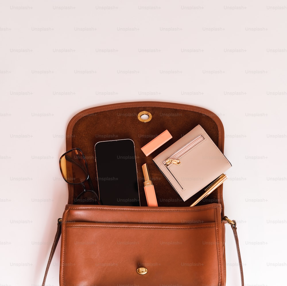 a brown purse with a cell phone and a wallet