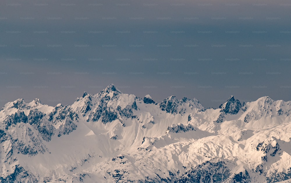 um avião voando sobre uma cordilheira coberta de neve