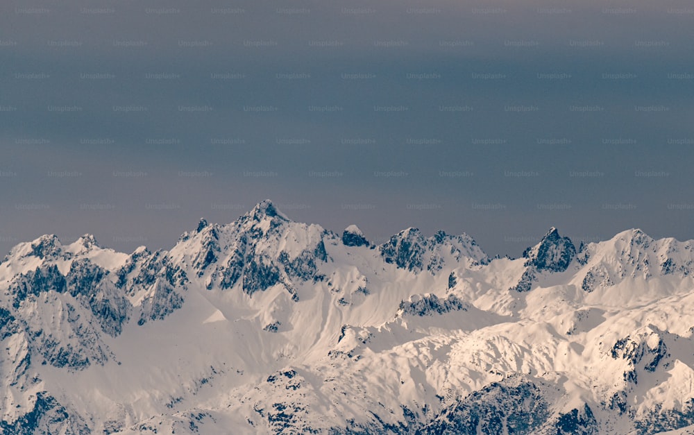 Ein Flugzeug fliegt über eine schneebedeckte Bergkette