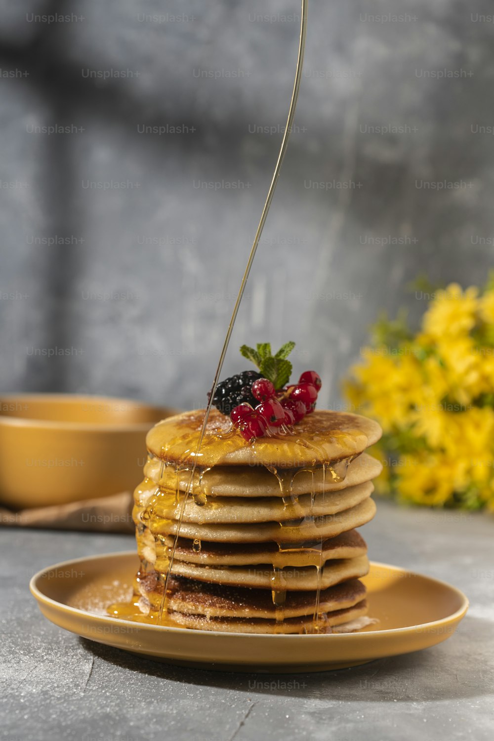 a stack of pancakes with syrup and berries on top