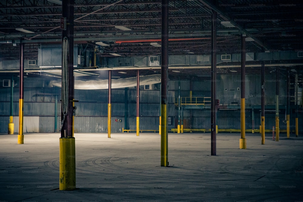 an empty warehouse with yellow poles and yellow posts