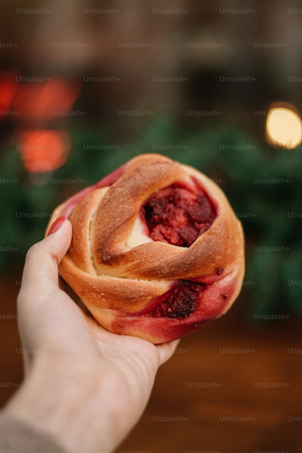 a person holding a pastry with a bite taken out of it