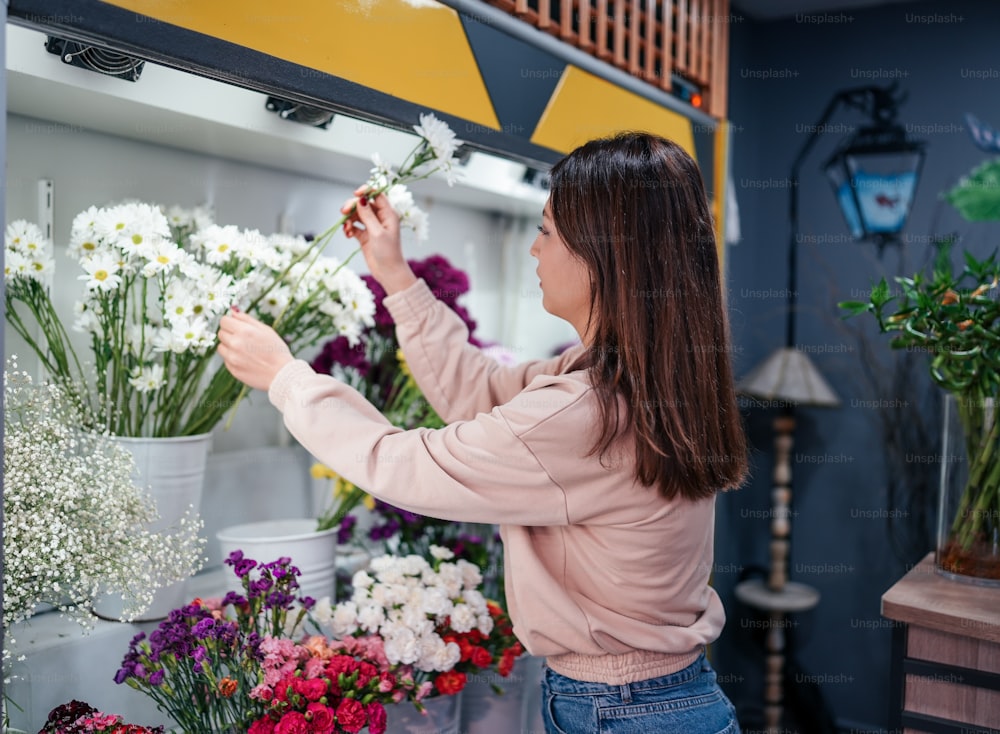 Una donna che organizza i fiori in un negozio di fiori