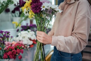 une personne tenant un bouquet de fleurs dans ses mains