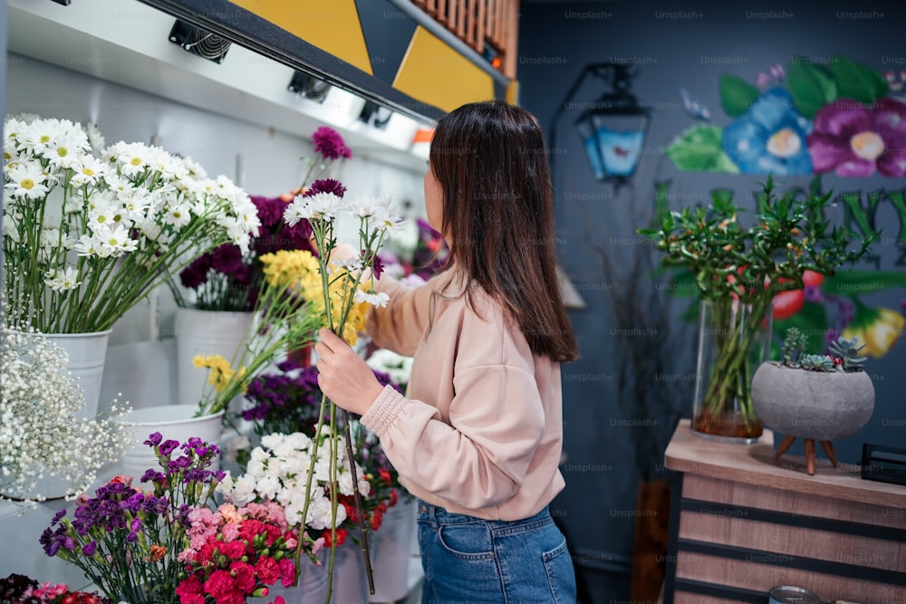 Una donna che organizza i fiori in un negozio di fiori