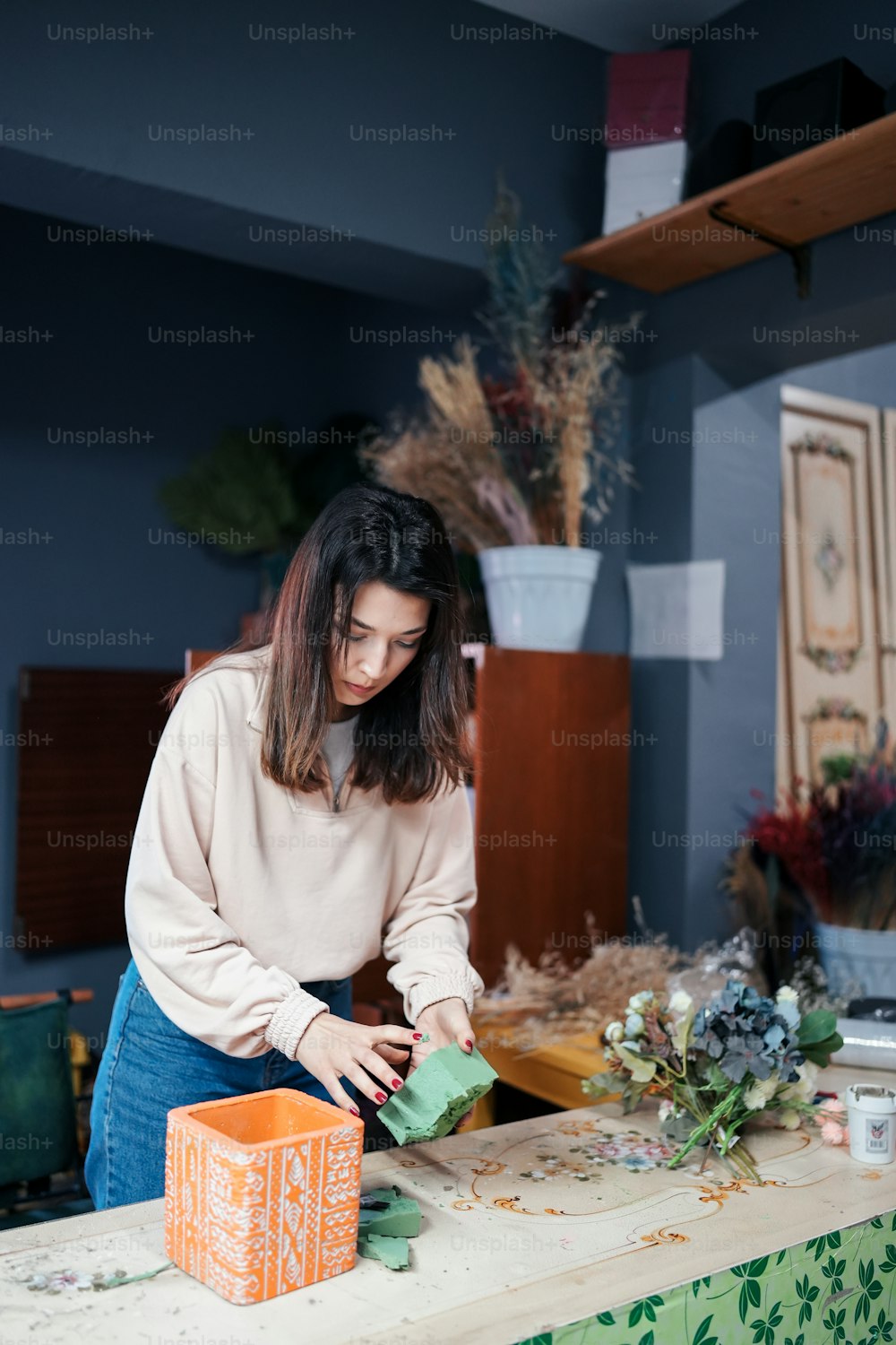 a woman standing at a table cutting up a piece of paper