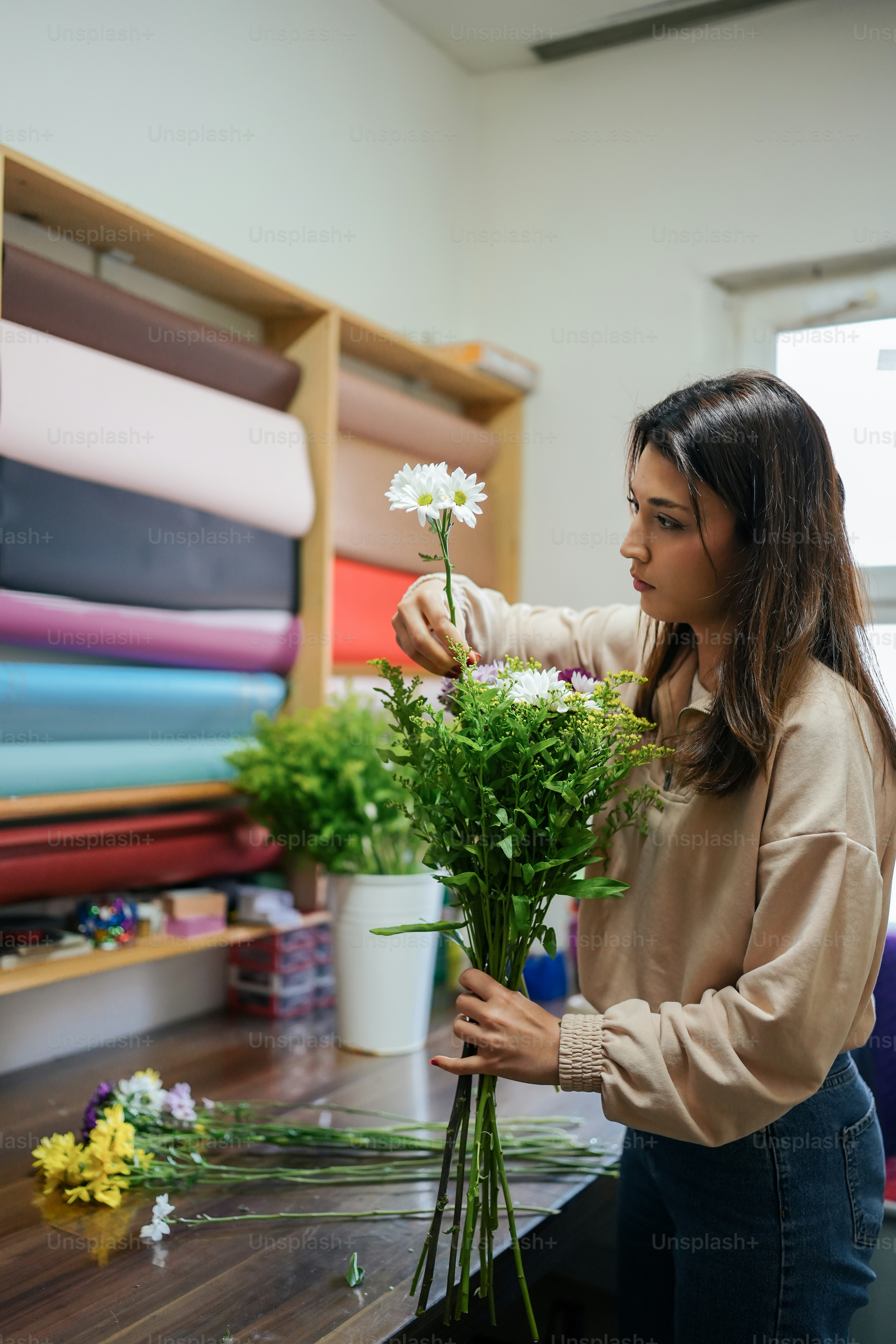 Eine Frau arrangiert Blumen in einem Blumenladen