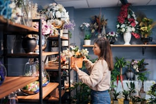 a woman arranging flowers in a flower shop