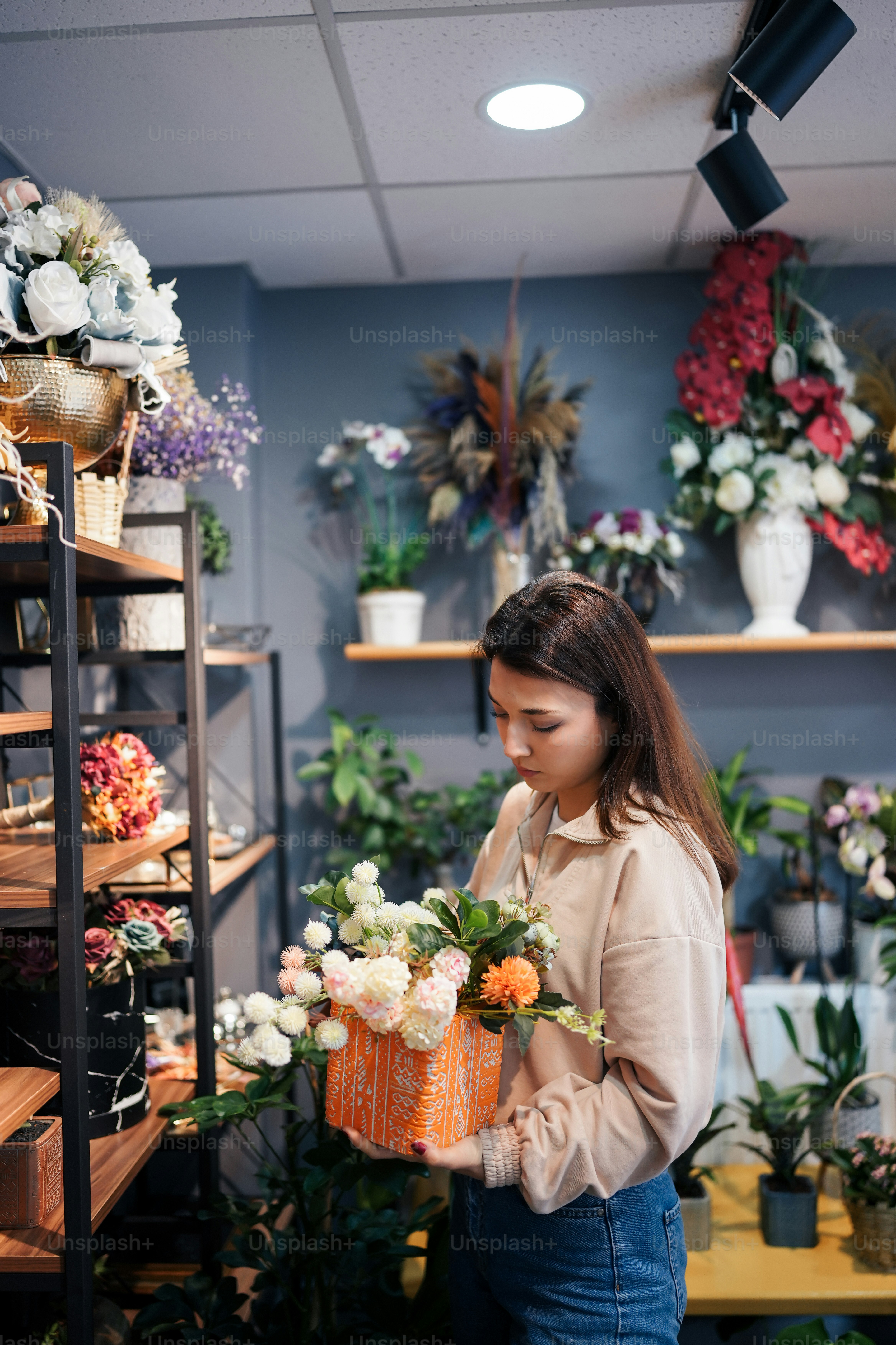 a woman holding a basket of flowers in a flower shop