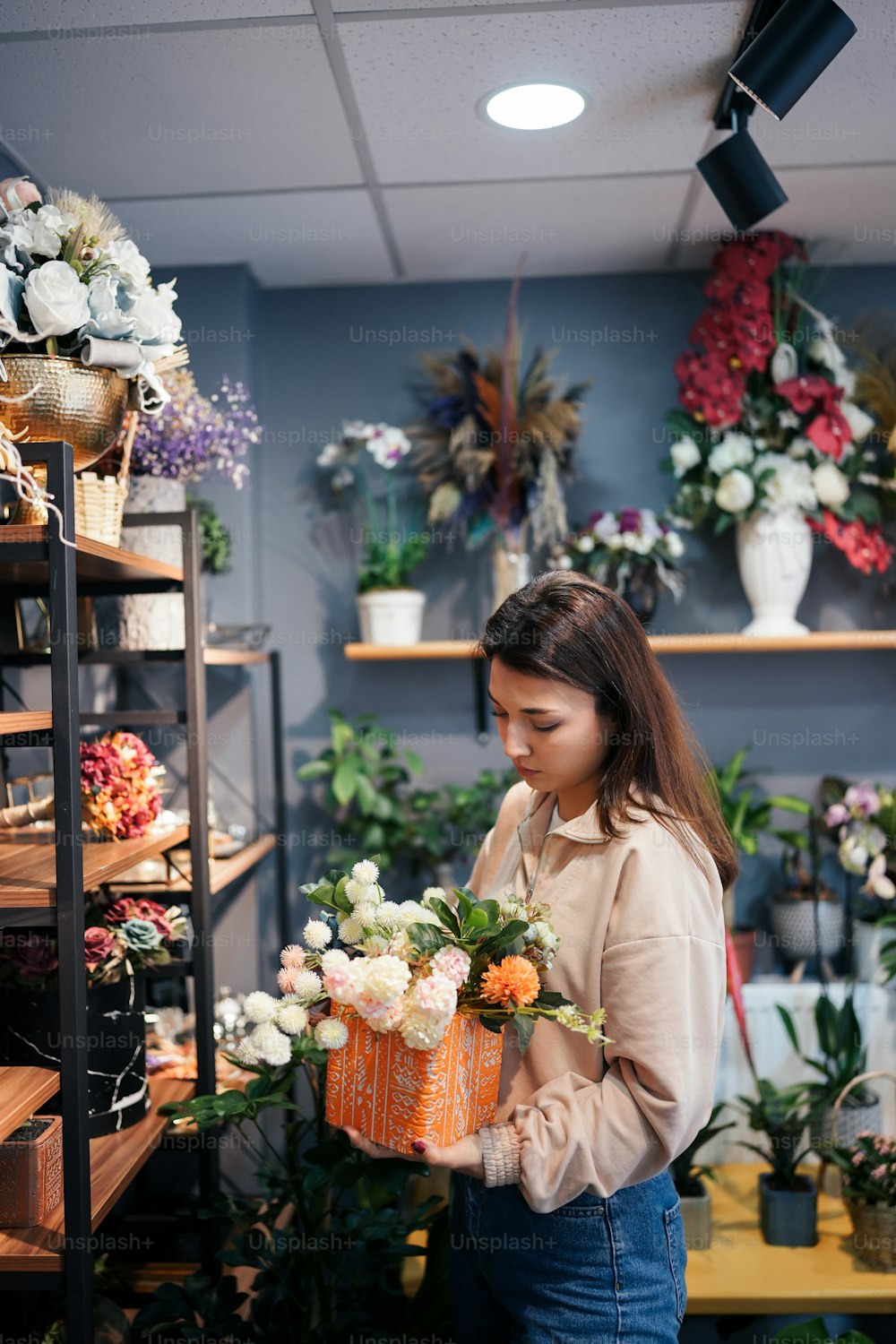 una donna che tiene un cesto di fiori in un negozio di fiori